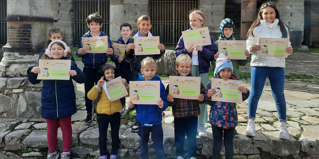 Piccoli archeologi crescono bambini in gruppo che mostrano il loro attestato di archeologo