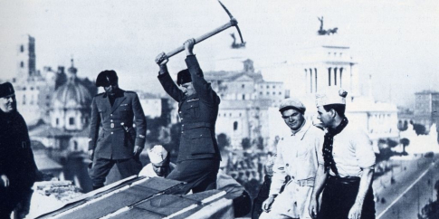 18 febbraio 1835. Mussolini dà il primo colpo di piccone per la demolizione di un edificio. Sullo sfondo: il tratto verso Piazza Venezia della nuova Via dell’Impero. Istituto Luce, Archivio Storico.